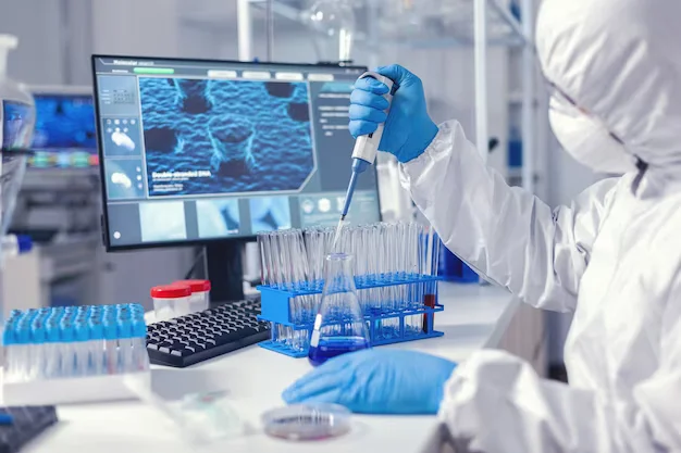 Laboratory employee pipettes DNA strands in front of a screen