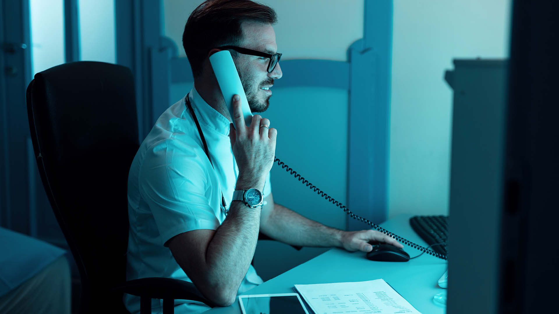 Doctor on the phone in the office during night work.