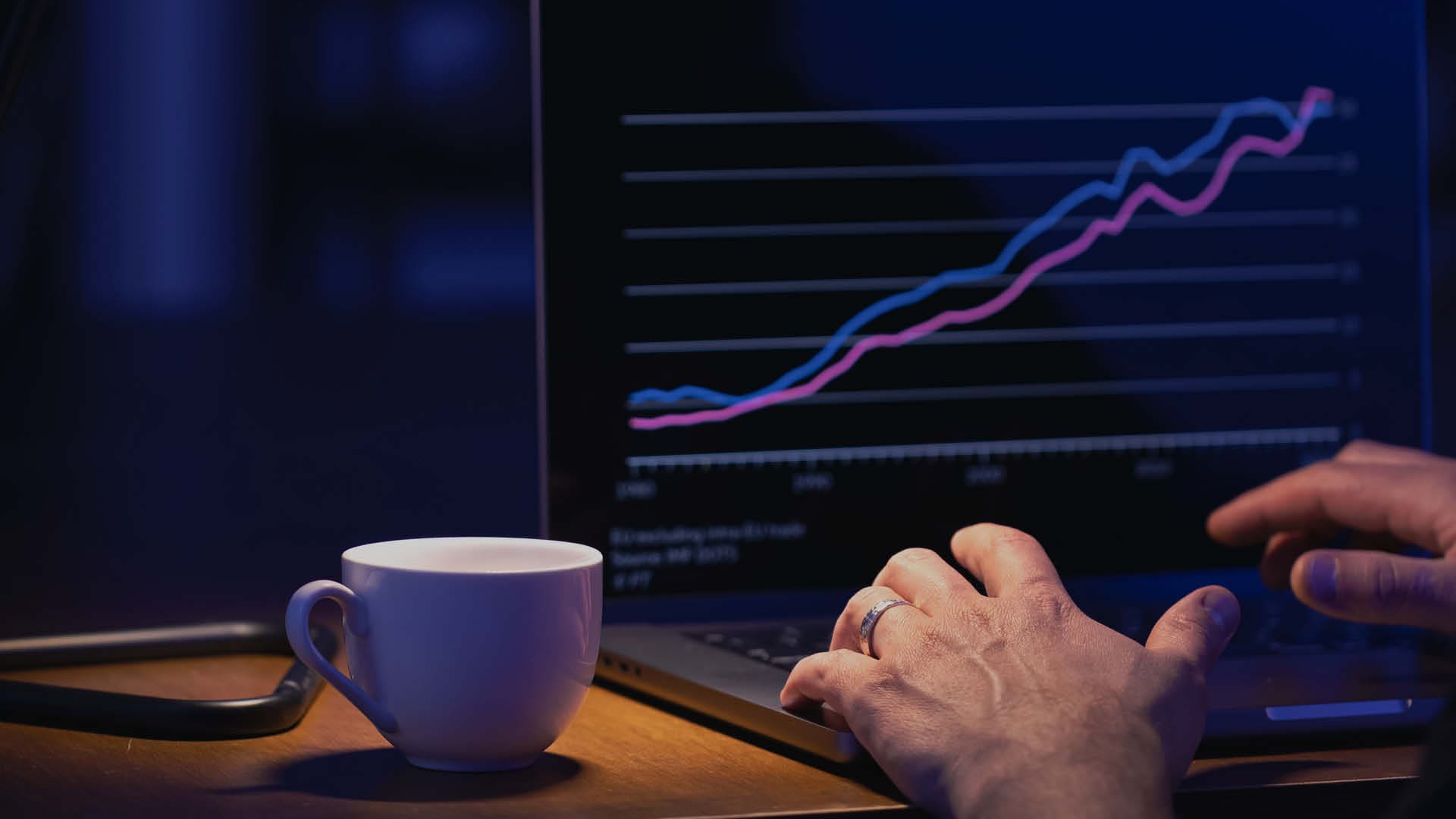 Laptop mit Wachstumsdiagramm und Kaffeetasse auf Holztisch.