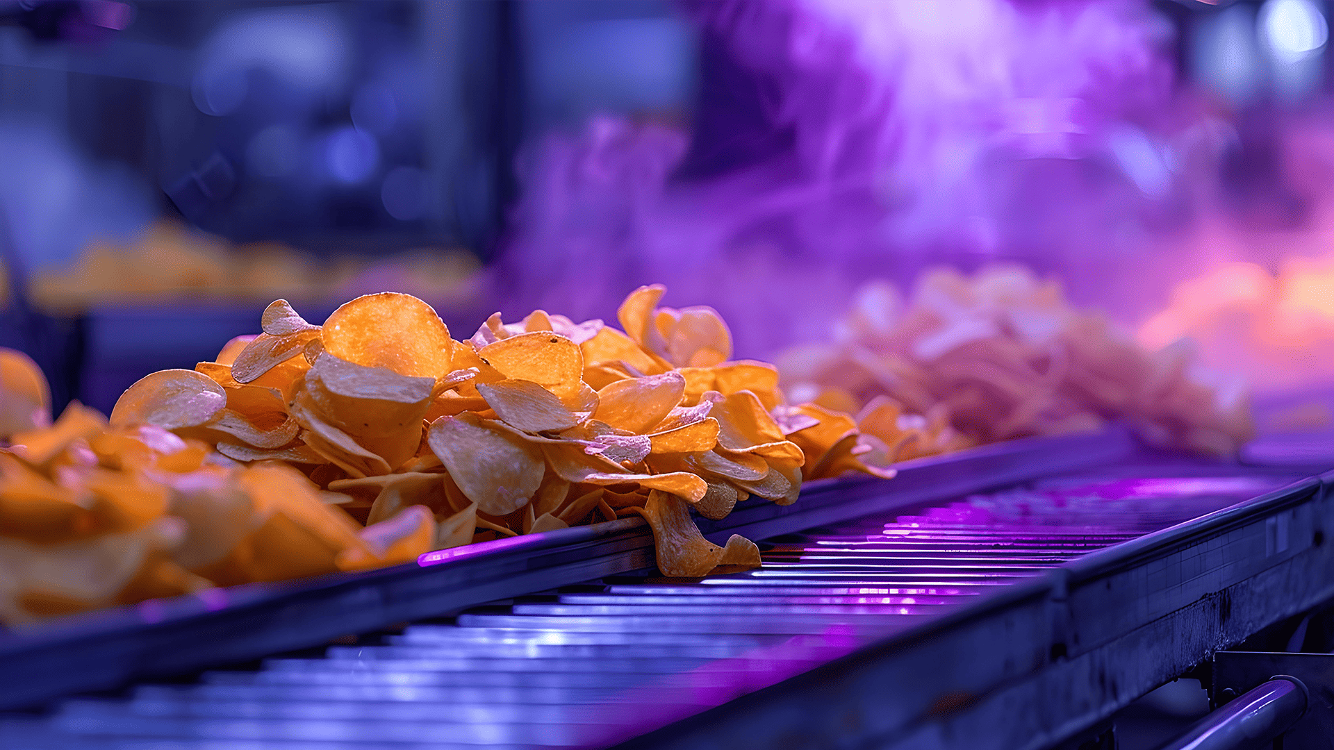 Kartoffelchips auf einem Förderband in einer Fabrik mit violetter Beleuchtung