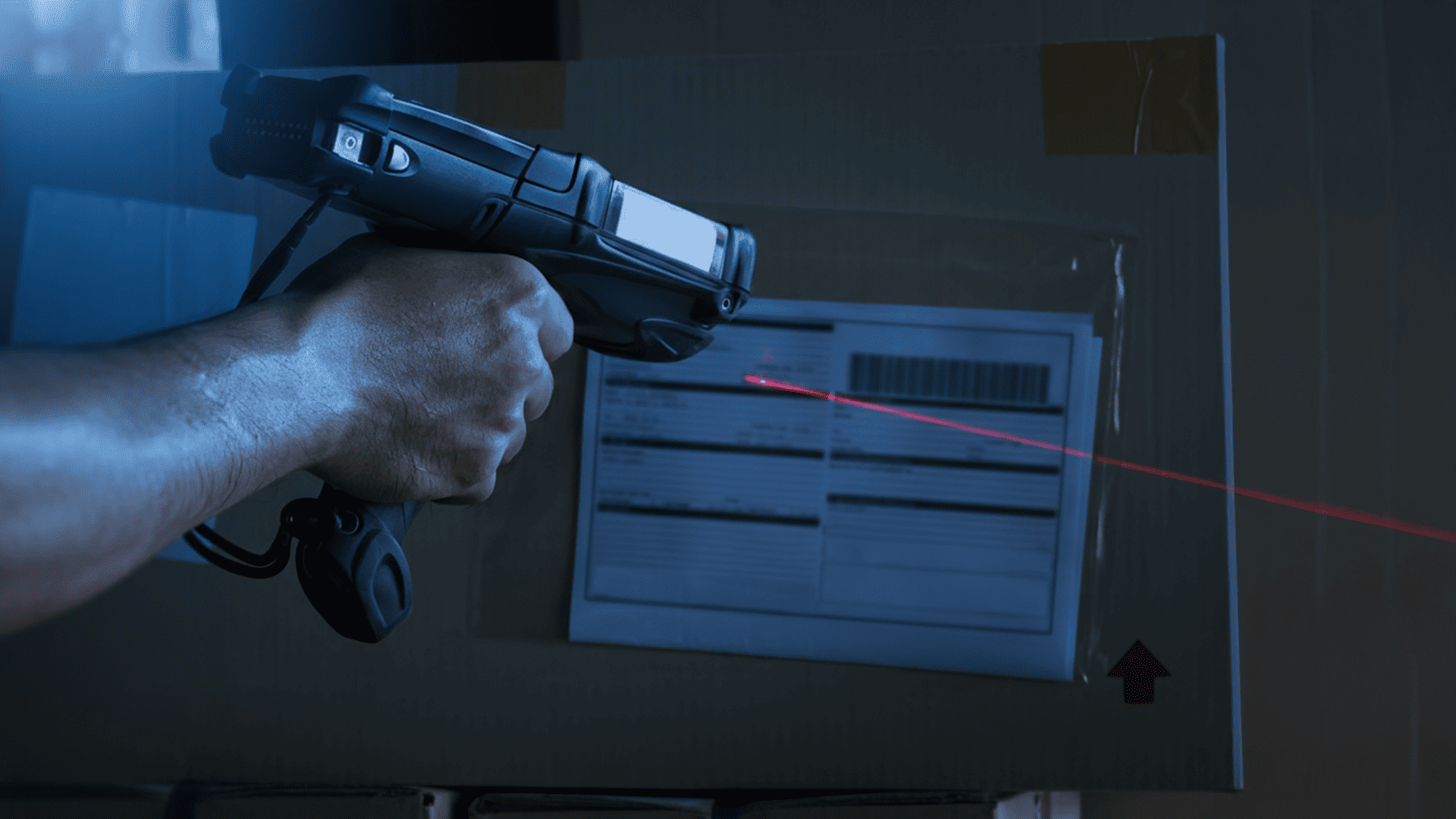 Hand hält Scanner und scannt Barcode auf Paket.