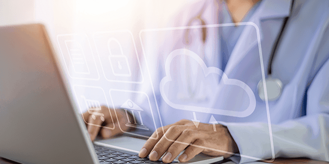 Person vor einem Laptop mit virtuellem Cloud-Icon