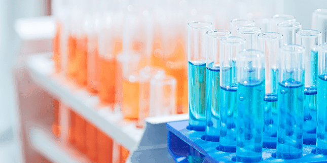 Reagenzgläser mit oranger und blauer Flüssigkeit